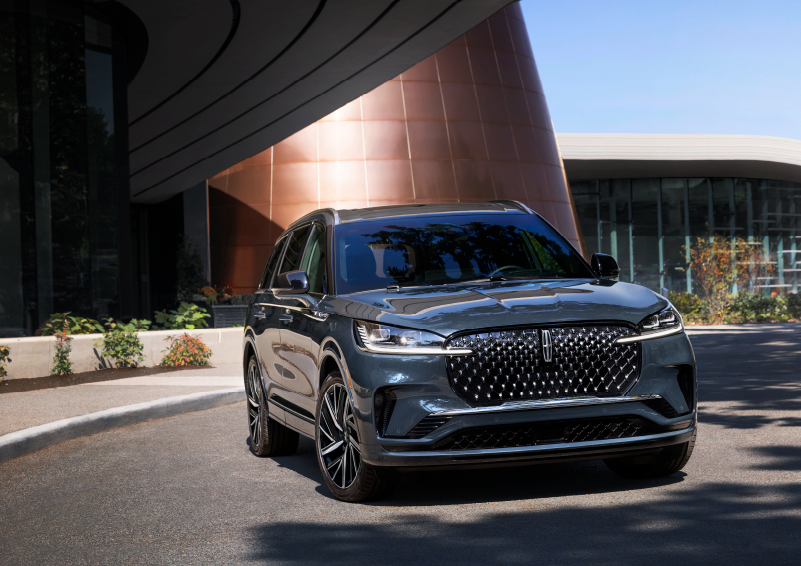 A gray 2025 Lincoln Aviator® SUV is parked outside a modern building with the sun shining. | Dave Sinclair Lincoln St. Peters in Saint Peters MO
