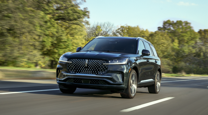 A 2025 Lincoln Black Label Aviator® SUV is being driven down a road lined with trees. | Dave Sinclair Lincoln St. Peters in Saint Peters MO