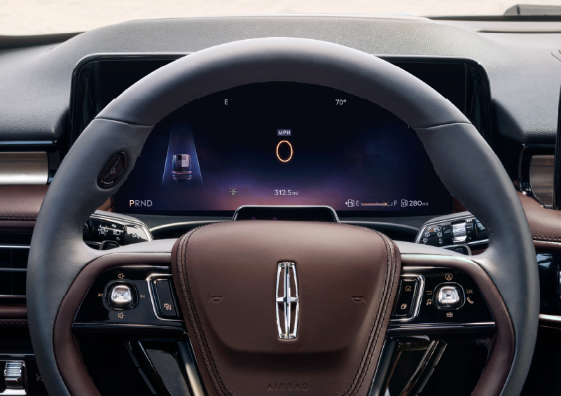 The steering wheel of 2025 Lincoln Aviator® SUV is shown with black and brown accents. | Dave Sinclair Lincoln St. Peters in Saint Peters MO