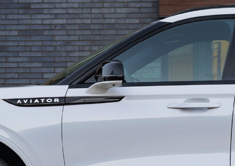 The driver’s side door and fender badging of a white 2026 Lincoln Aviator® SUV are showcased. | Dave Sinclair Lincoln St. Peters in Saint Peters MO