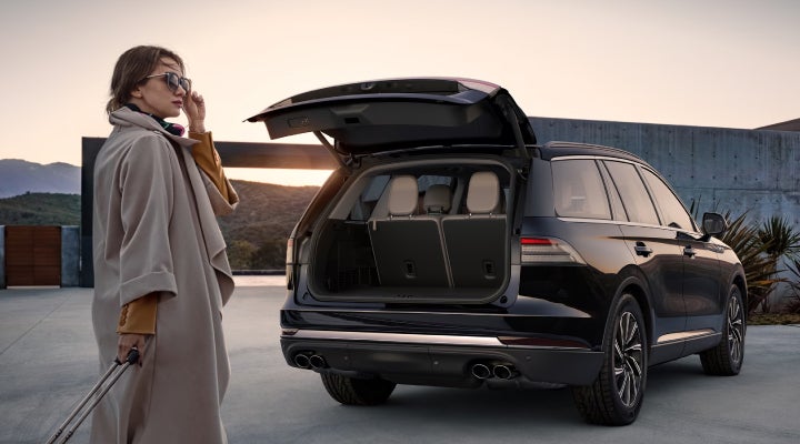 A woman approaches a 2026 Lincoln Aviator® SUV with its rear liftgate open. | Dave Sinclair Lincoln St. Peters in Saint Peters MO