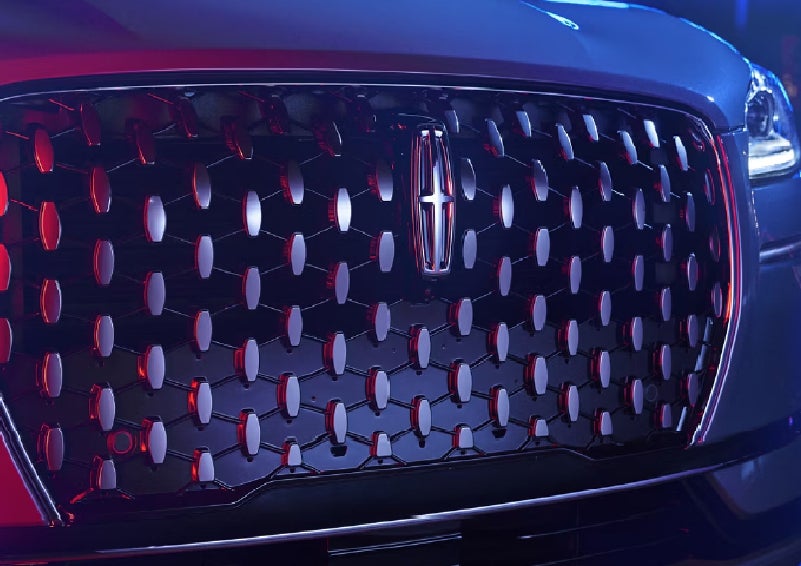 The grille of a 2025 Lincoln Corsair&reg; SUV reflects neon light at night. | Dave Sinclair Lincoln St. Peters in Saint Peters MO