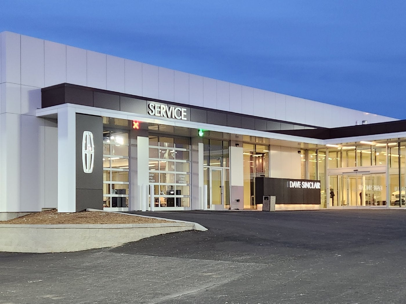 Service department entrance at Dave Sinclair Lincoln St. Peters at dusk with the lot in front