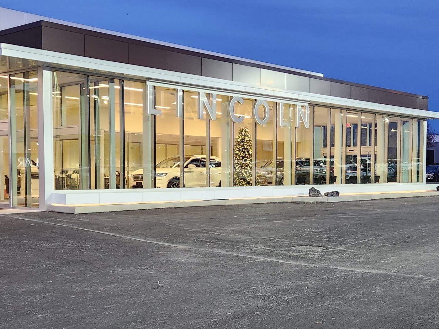 Showroom exterior at Dave Sinclair Lincoln St. Peters at dusk with the lot in the foreground