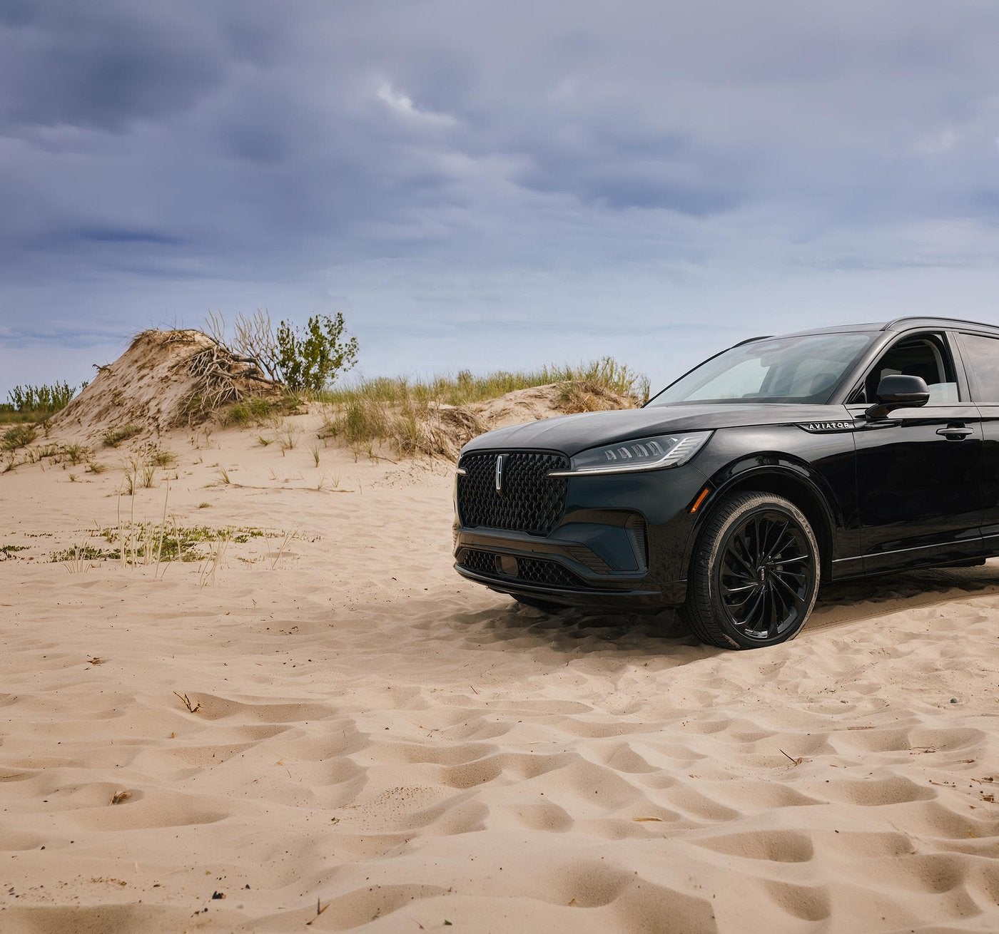 Black Lincoln Aviator parked in the sand dunes on a hot summer day
