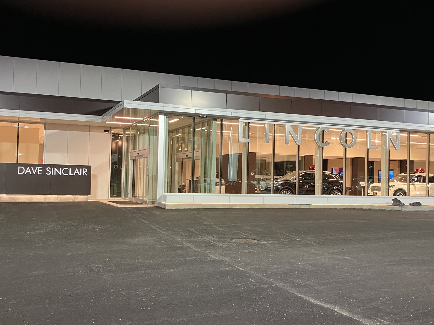 Lincoln showroom at Dave Sinclair Lincoln St. Peters lit up at night with vehicles inside