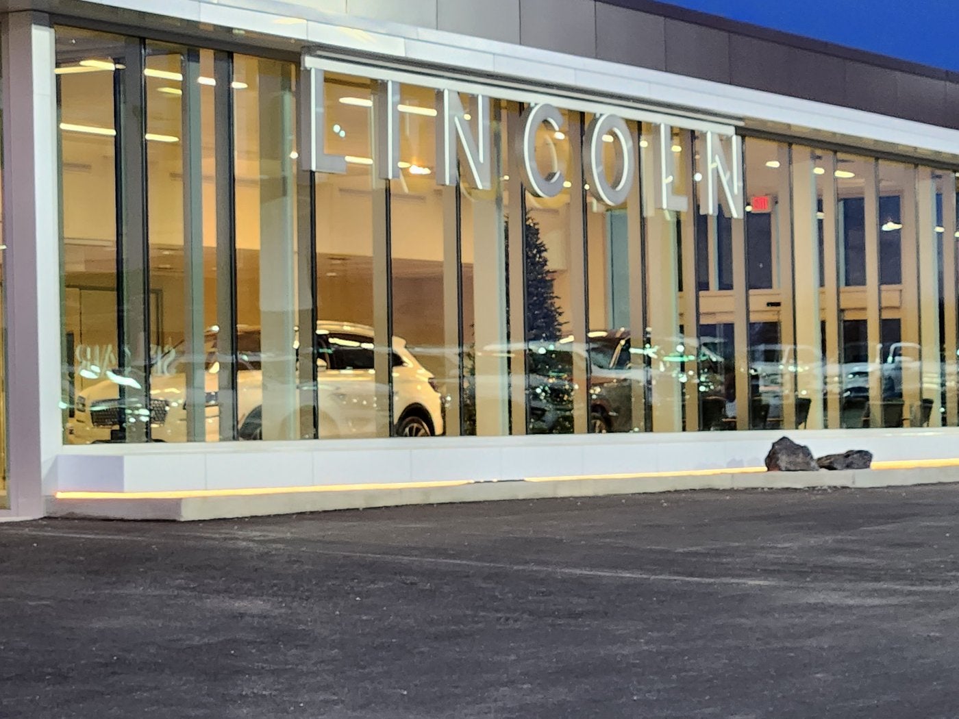 Glass showroom with Lincoln lettering at Dave Sinclair Lincoln St. Peters on a clear afternoon