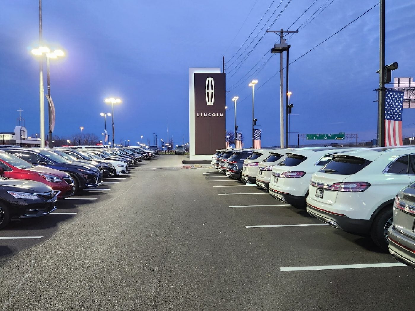 Lincoln star sign and parking lot lights at Dave Sinclair Lincoln St. Peters in the evening