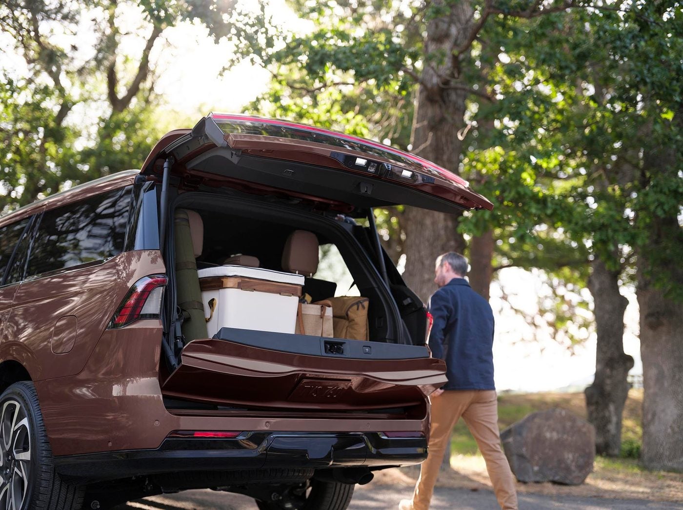 Copper Lincoln Navigator with the split gate open as a man walks to it